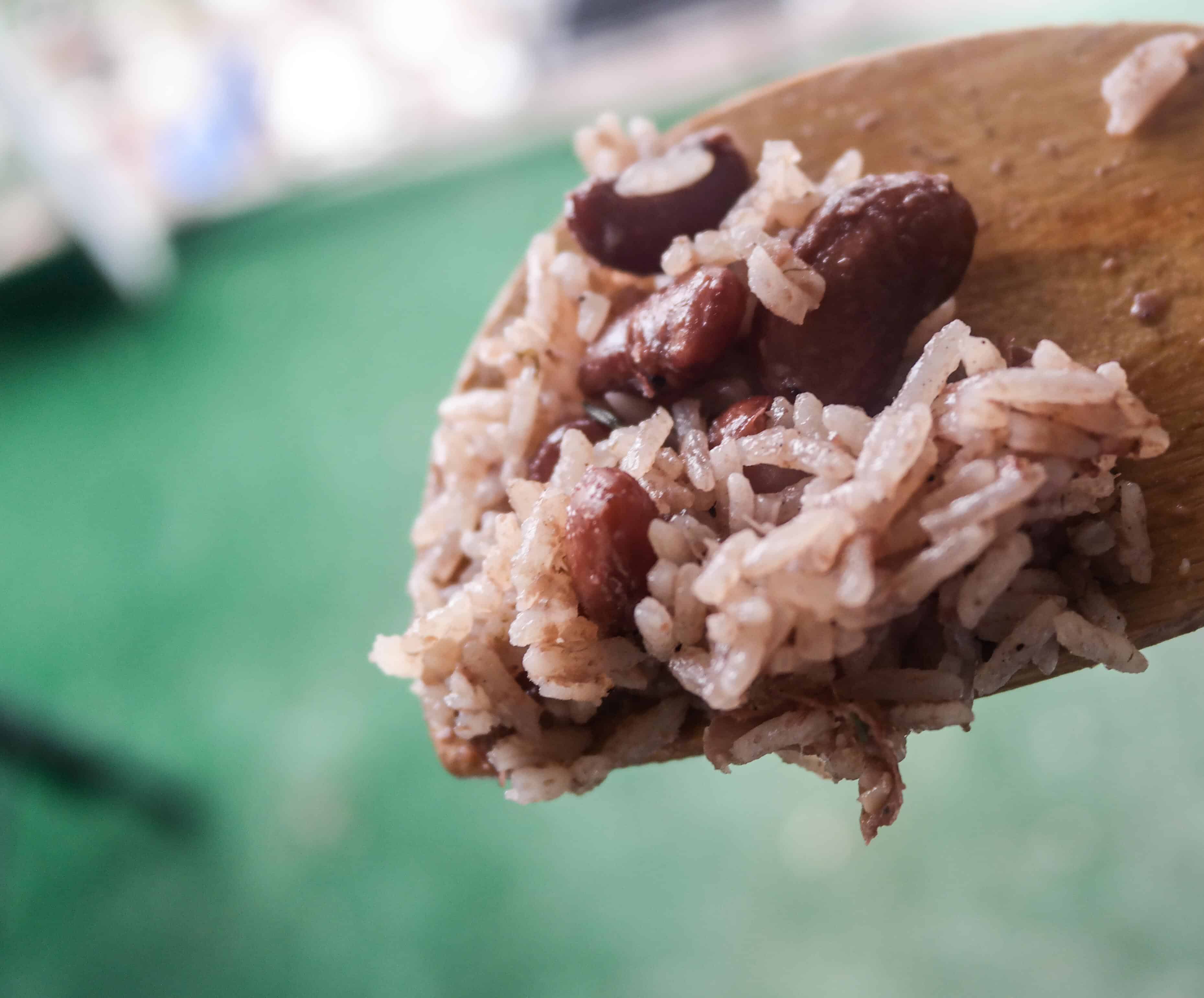 Authentic Jamaican Rice And Peas on a wooden spoon