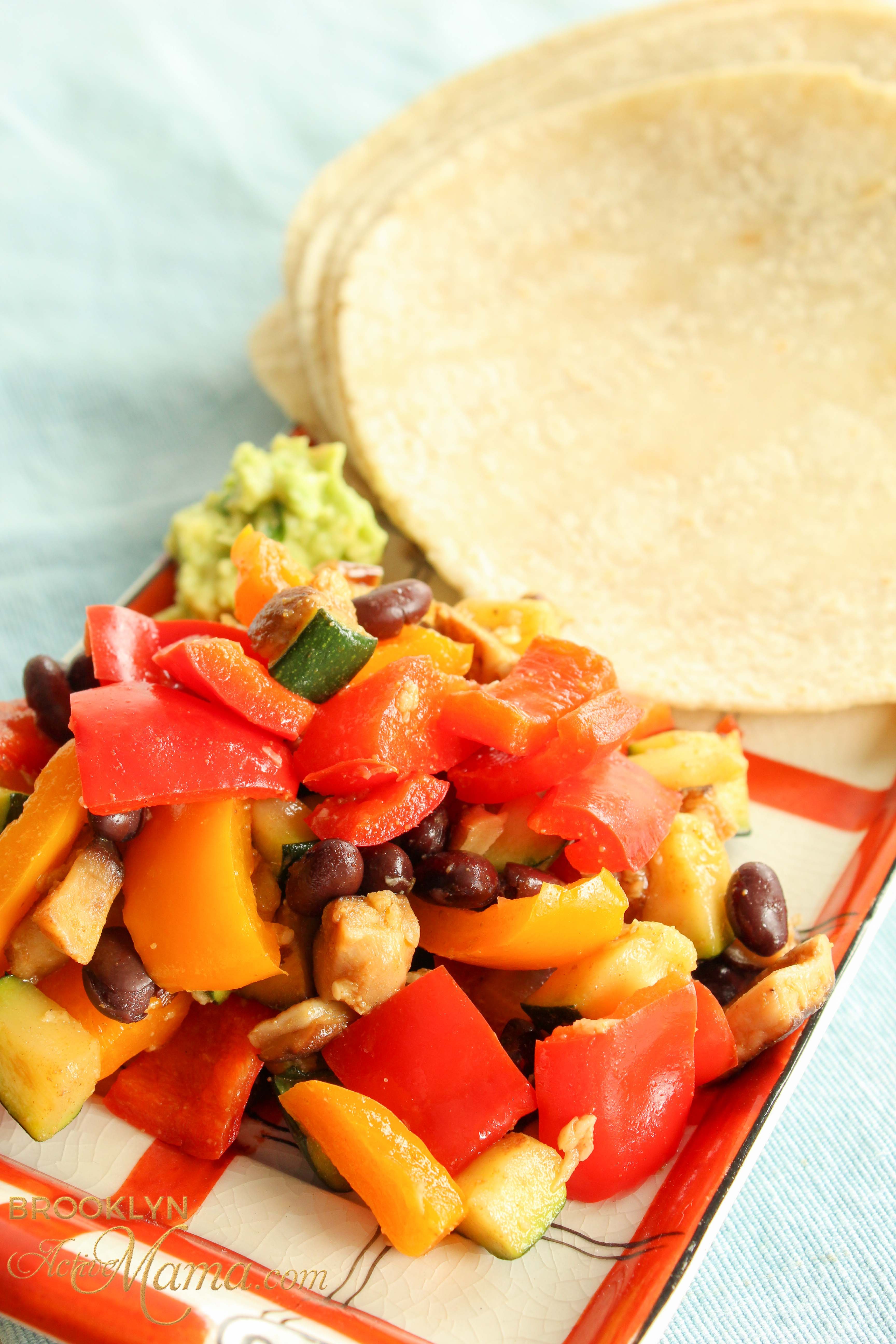 vegetable tacos with red and yellow peppers, beans cheese and guacamole