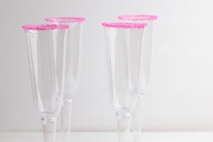 empty champagne glasses with pink sugar rims