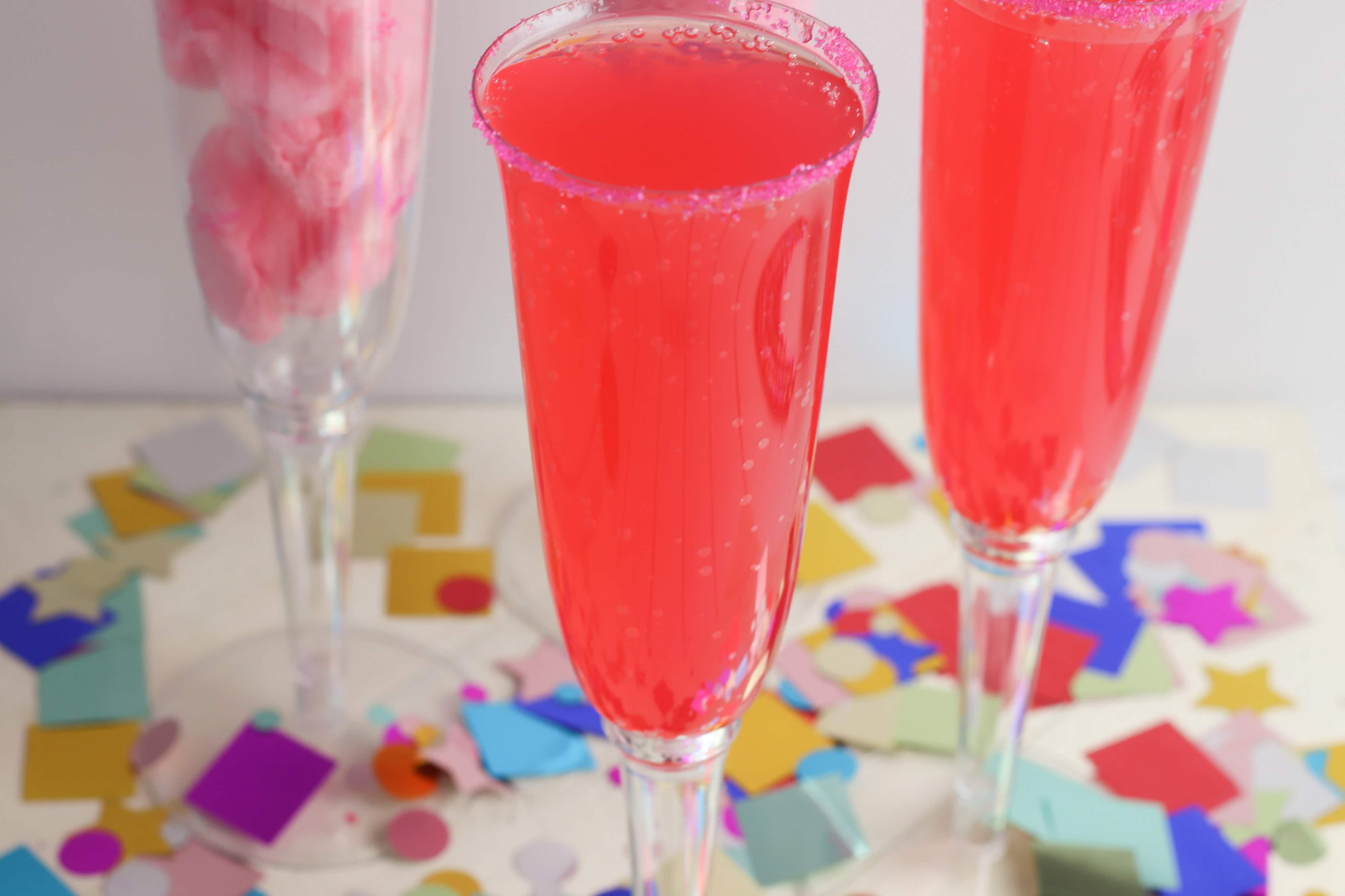 This fun and sweet non alcoholic tasty cotton candy mocktail has a very beautiful and festive pink color! This is a super fun drink to make for kids or non drinkers at a party! The recipe calls for cotton candy, pink sugar and strawberry soda which makes for a pretty sparking pink drink. This is a great sparkling drink recipe for a crowd! Your guests will be so impressed! #mocktail #nonalcoholicdrinks #nonalcoholic #mocktailrecipe