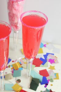 This fun and sweet non alcoholic tasty cotton candy mocktail has a very beautiful and festive pink color! This is a super fun drink to make for kids or non drinkers at a party! The recipe calls for cotton candy, pink sugar and strawberry soda which makes for a pretty sparking pink drink. This is a great sparkling drink recipe for a crowd! Your guests will be so impressed! #mocktail #nonalcoholicdrinks #nonalcoholic #mocktailrecipe
