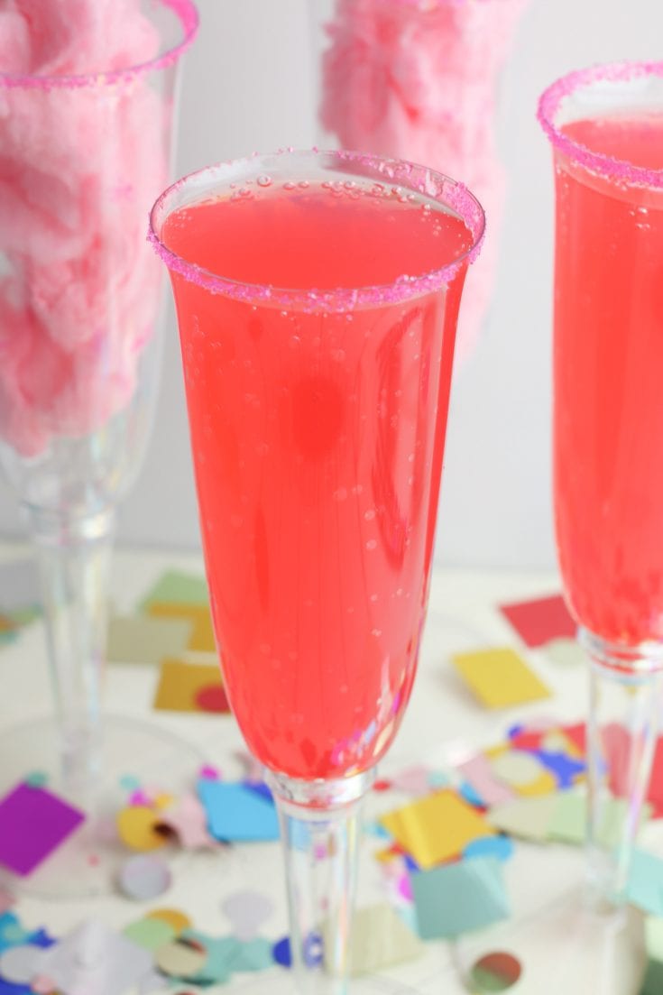 This fun and sweet non alcoholic tasty cotton candy mocktail has a very beautiful and festive pink color! This is a super fun drink to make for kids or non drinkers at a party! The recipe calls for cotton candy, pink sugar and strawberry soda which makes for a pretty sparking pink drink. This is a great sparkling drink recipe for a crowd! Your guests will be so impressed! #mocktail #nonalcoholicdrinks #nonalcoholic #mocktailrecipe