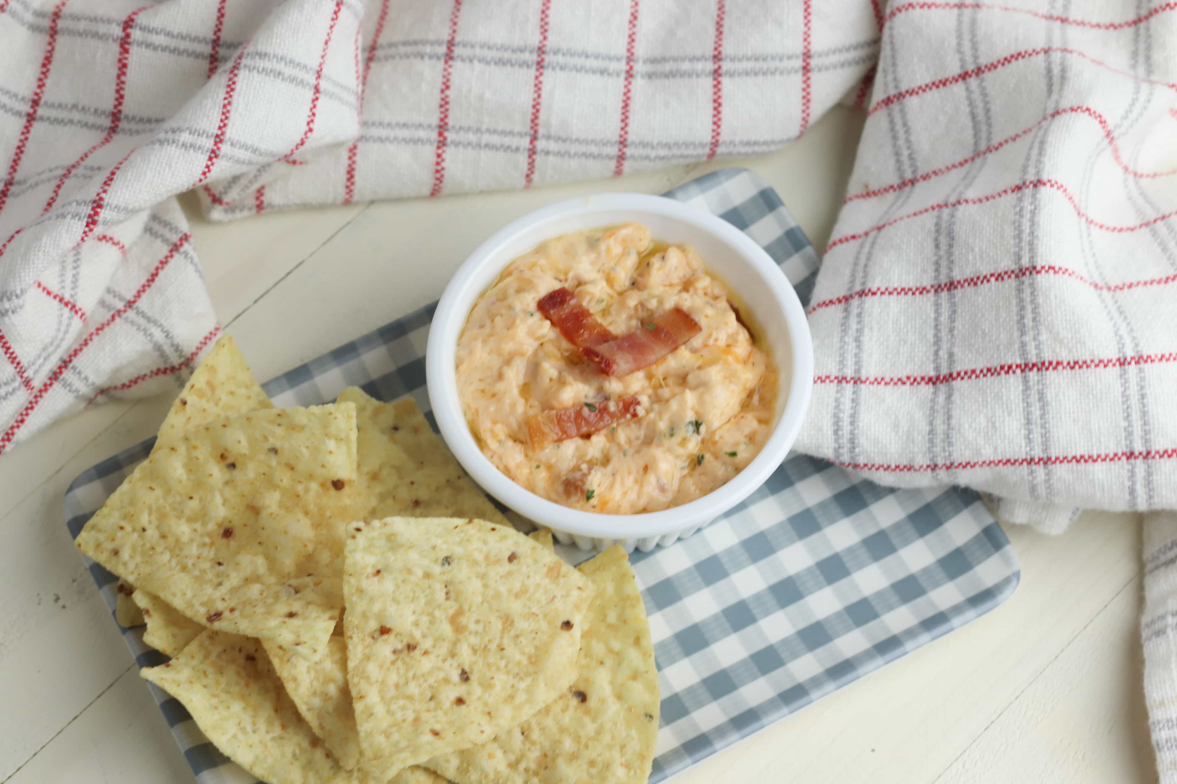 Here is a super easy and delicious bacon cheddar dip that is a sure crowd pleaser! This dip is made on the stove, served warm with chips or crackers. Three easy main ingredients include cream cheese, bacon and cheddar cheese. #appetizers #dips #cheesedip