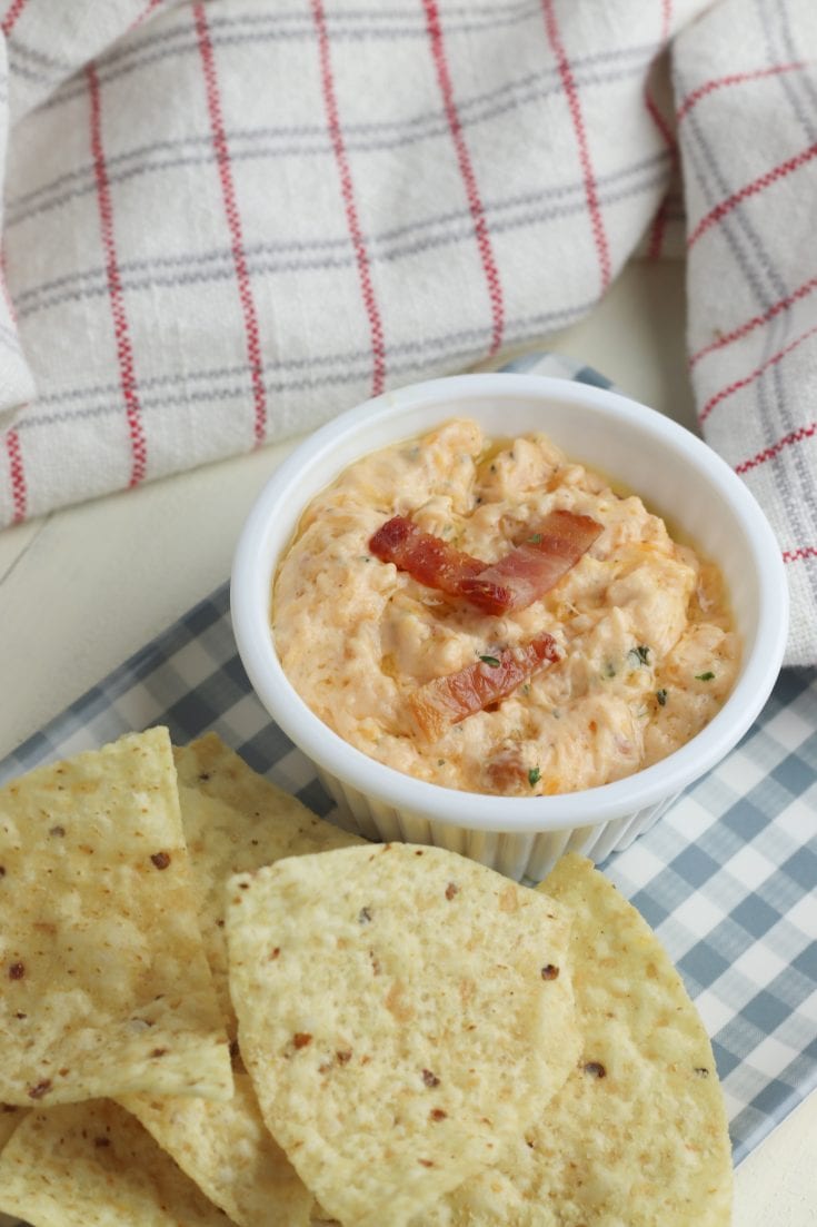 Here is a super easy and delicious bacon cheddar dip that is a sure crowd pleaser! This dip is made on the stove, served warm with chips or crackers. Three easy main ingredients include cream cheese, bacon and cheddar cheese. #appetizers #dips #cheesedip