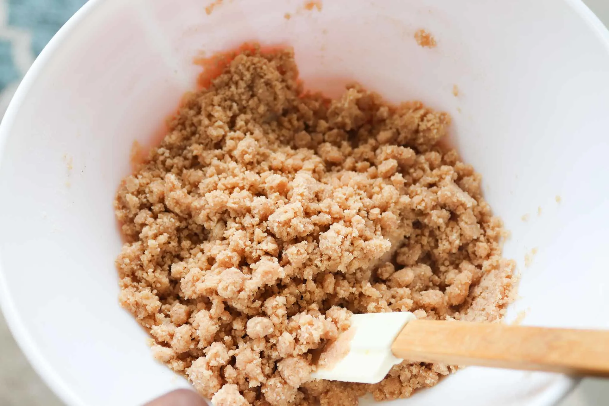 mixing the coffee cake crumb topping in a white bowl