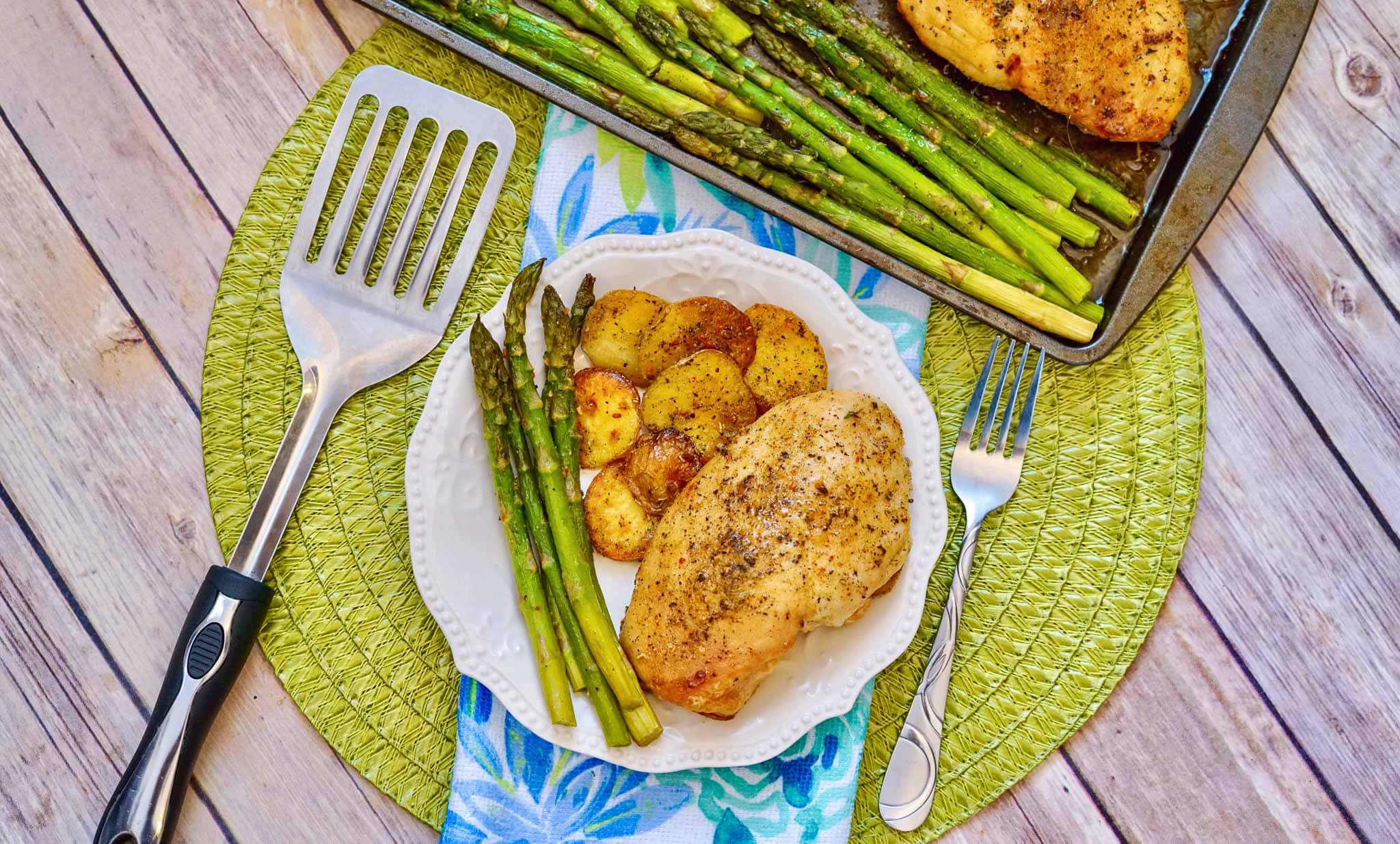 Italian Chicken Sheetpan Dinner with Asparagus On A White plate with spatula