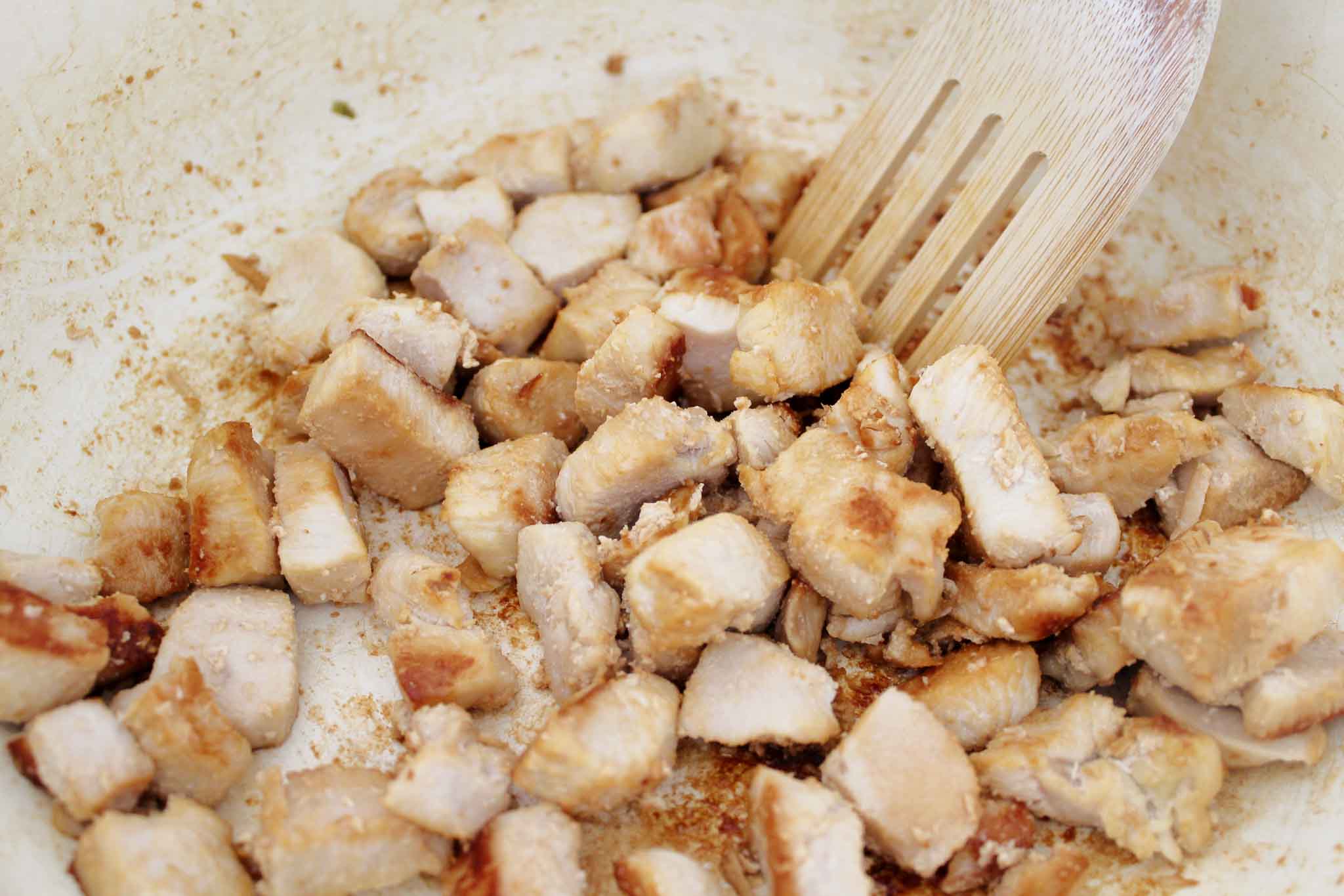 chopped chicken has been cooked in a white pan