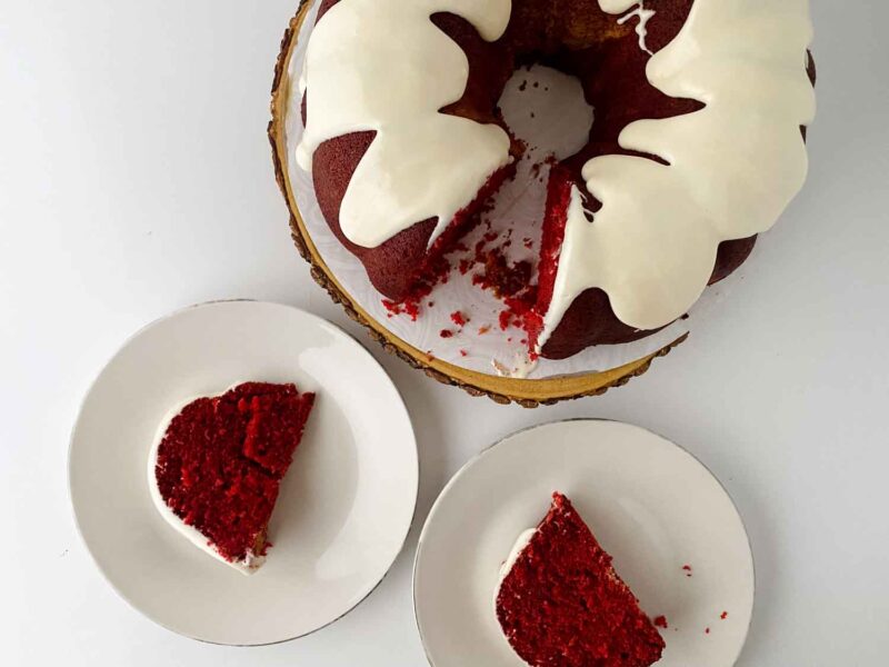 Red Velvet Pound Cake Recipe With Cream Cheese Glaze sliced with two pieces on white plates