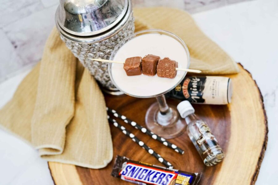 snickers martini in a martini glass in front of a cocktail shaker